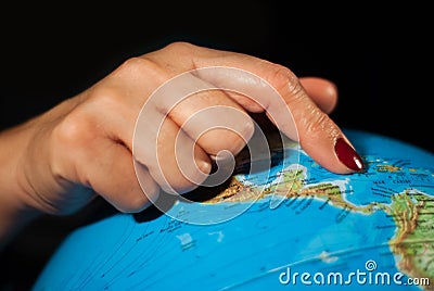 Hands of a woman holding a globe of the planet earth with marked places to travel on vacation Stock Photo