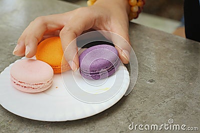 Hands of the woman picked a macaron Stock Photo