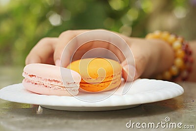 Hands of the woman picked a macaron Stock Photo