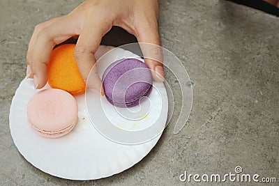 Hands of the woman picked a macaron Stock Photo