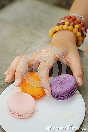 Hands of the woman picked a macaron Stock Photo