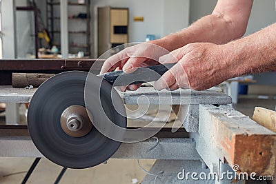 Hands of worker wich is sharpering knife on grindstone Stock Photo