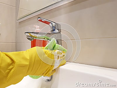 Hands in yellow gloves wash maid sink clean sanitary in the ceramic bathroom wash Stock Photo
