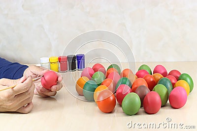 Hands of young christian coloring eggs on marble top background preparing for easter day. Stock Photo