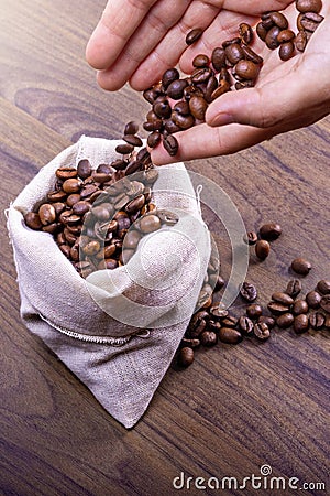 Hands of a young girl removing coffee beans from a sack. International coffee day concept. October 1st Stock Photo