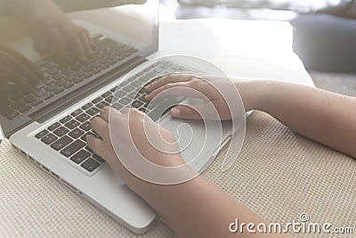 Hands of a young girl typing on a laptop Stock Photo