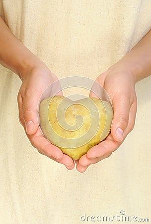 Hands of young woman holding potato in heart shape Stock Photo