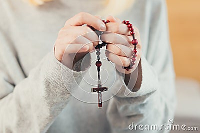 Hands young woman prays to God, folded her arms on her chest uses a rosary and a crucifix Stock Photo