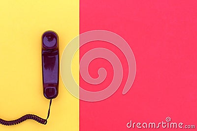 The handset lies on yellow and red colors. Stock Photo