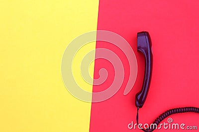 The handset lies on yellow and red colors. Stock Photo