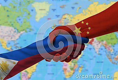 Handshake between China and the Philippines flags painted on hands.With background of world map. Stock Photo