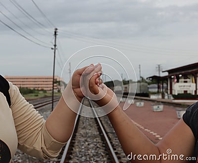 Handshake conveys good friendship in the train station background. Stock Photo