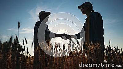 handshake farmer wheat. business partnership agriculture concept. silhouette two farmers shaking hands conclude a Stock Photo