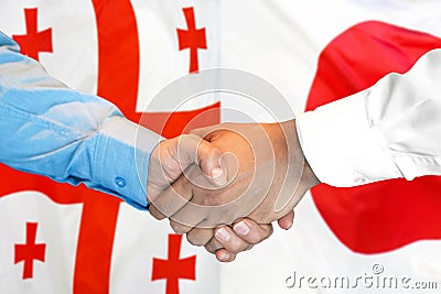 Handshake on Georgia and Japan flag background Stock Photo