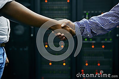 Handshake, partnership or people in server room of data center worker for network help with IT support. Cybersecurity Stock Photo