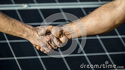 Handshake of two businessmen on a background surface of solar panels Stock Photo