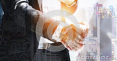 Handshaking of businessmen hands overlay with cityscape Stock Photo