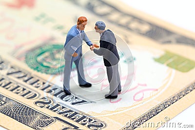 Handshaking businessmen on usa dollar banknote. Business company profitable deal. Stock Photo