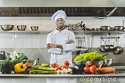 handsome african american chef standing at restaurant kitchen with crossed arms and looking Stock Photo