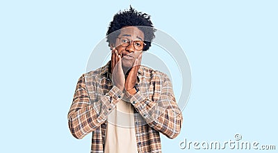 Handsome african american man with afro hair wearing casual clothes and glasses tired hands covering face, depression and sadness, Stock Photo