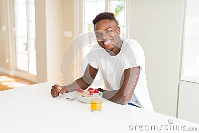 Handsome african american man eating heatlhy cereals and berries as breakfast Stock Photo