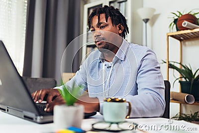 African American smiling freelancer working remotely from home Stock Photo