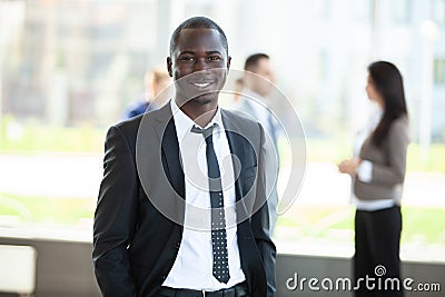Handsome african businessman with group of businesspeople on background. Stock Photo