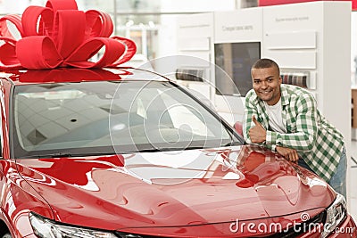 Handsome African man choosing new car at dealership Stock Photo