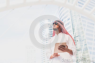 Handsome arab business man hold the digital tablet and looking to left side. Arab business man standing outside office. Stock Photo