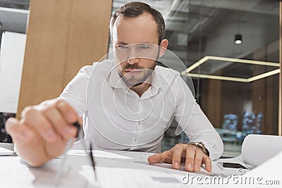 handsome architect with compass drawing building plans Stock Photo