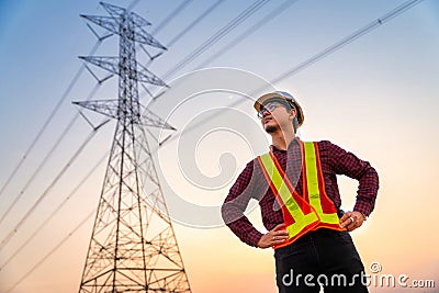 Handsome asian electrical engineer standing at high voltage pylon, Electricity generation concept Stock Photo
