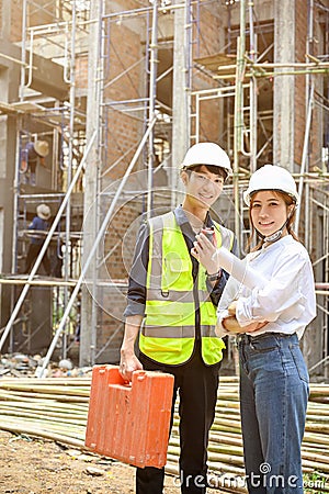 Handsome Asian male civil engineer and female architect in the construction site Stock Photo