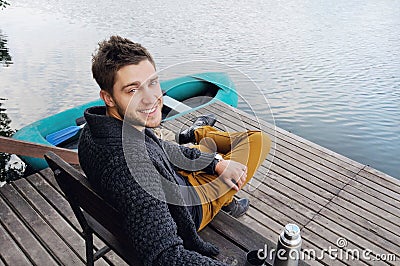 handsome attractive man on the wooden pier at the lake, lifestyle Stock Photo