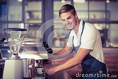 Handsome barista making a cup of coffee Stock Photo