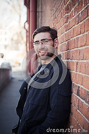 Handsome bearded glasses man in a black shirt on the background of the gray wall Stock Photo