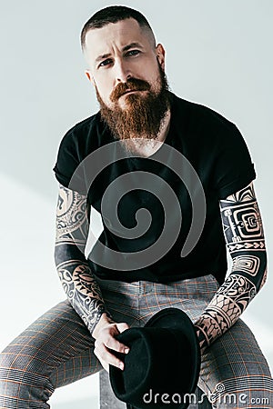 handsome bearded tattooed man looking at camera Stock Photo