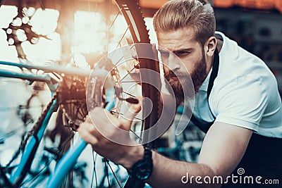 Handsome Bike Mechanic Repair Bicycle in Workshop Stock Photo