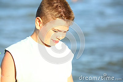 Handsome boy in shorts and a t-shirt teenager launches a kite on the sky on the seashore Stock Photo