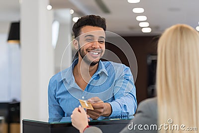 Handsome Business Man Fashion Shop, Customer Give Credit Card Payment In Retail Store, Woman Serving Client Stock Photo