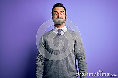 Handsome businessman with beard wearing casual tie standing over purple background puffing cheeks with funny face Stock Photo