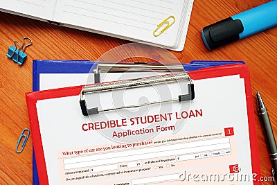 A handsome businessman showing a blank piece of paper with sign CREDIBLE STUDENT LOAN Application Form Stock Photo