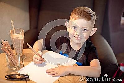 Handsome caucasian little boy painting at the table Stock Photo