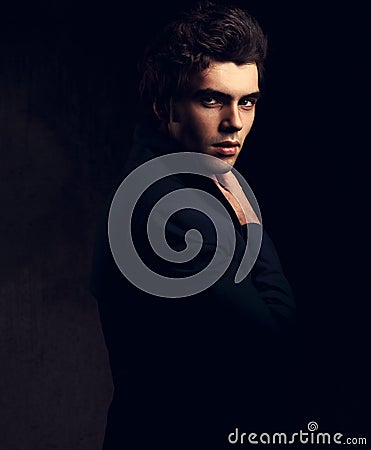 Handsome charismatic man looking serious in dark shadow dramatic Stock Photo