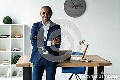 Handsome cheerful african american executive business man at the workspace office. Stock Photo