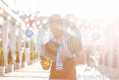 Handsome cheerful young arabian student with a stylish mustache and a beard with juice in his hands, walking around the Stock Photo