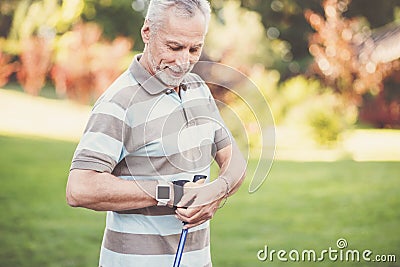 Handsome delighted man putting on the sports equipment Stock Photo