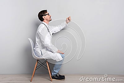 Handsome doctor gesturing on a grey background Stock Photo