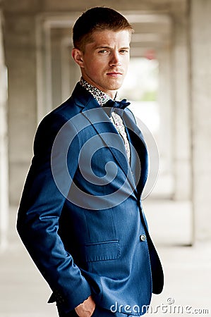 Handsome elegant man wears blue suit with bow tie. Stock Photo