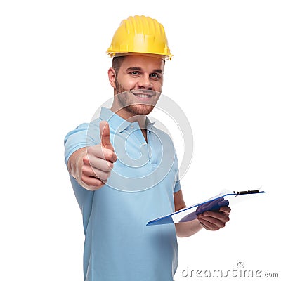 Handsome engineer makes thumbs up sign while holding blue files Stock Photo