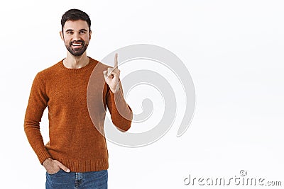 Handsome enthusiastic bearded family guy pointing finger up, cute dad found excellent gift for birthday of his kid Stock Photo